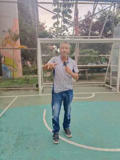 Jaime Ramirez con micrófono frente a un arco de microfútbol